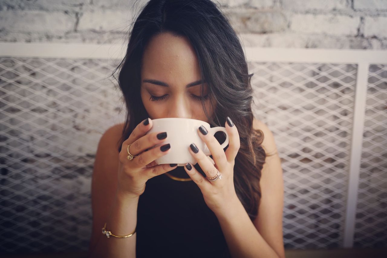 woman drinking from mug with diamond rings