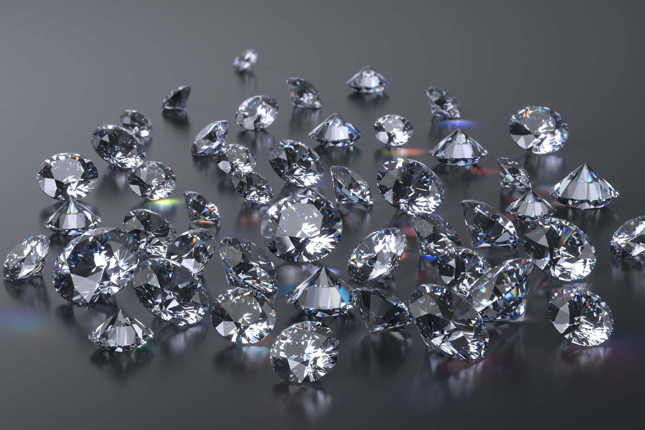 Shining round-cut diamonds displayed on a dark, reflective surface.