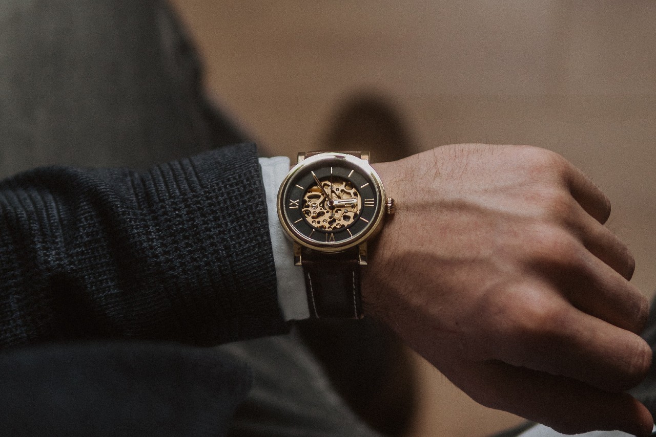 a man wearing a wrist watch with an open face revealing the mechanism